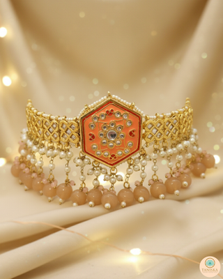 Luxury peach-orange meenakari Kundan choker necklace set with matching jhumka earrings and maang tikka, vibrant statement jewelry for South Asian bridal weddings and festive occasions.