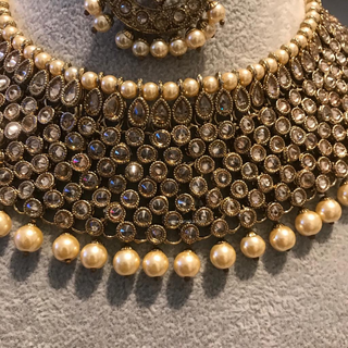 Luxury antique gold finish Kundan bridal necklace set featuring intricate detailing with matching jhumka earrings and maang tikka, elegant statement jewelry for South Asian weddings and nikah ceremonies, as seen in www.taniska.com