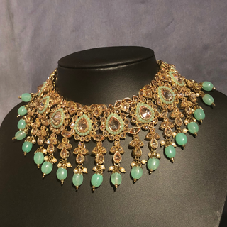 Luxury mint green Kundan bridal necklace set with matching jhumka earrings and maang tikka, elegant statement jewelry for South Asian weddings and nikah ceremonies.