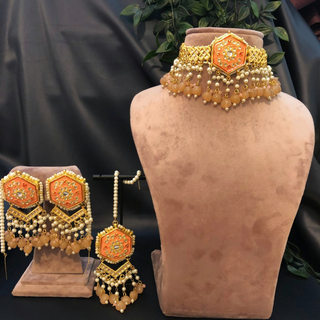 Luxury peach-orange meenakari Kundan choker necklace set with matching jhumka earrings and maang tikka, vibrant statement jewelry for South Asian bridal weddings and festive occasions.